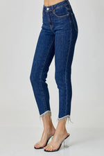 Blue jeans with fringe details on a white background