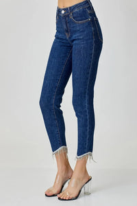 Blue jeans with fringe details on a white background