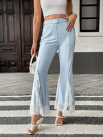 Woman wearing light blue pants with lace trim on a city street.