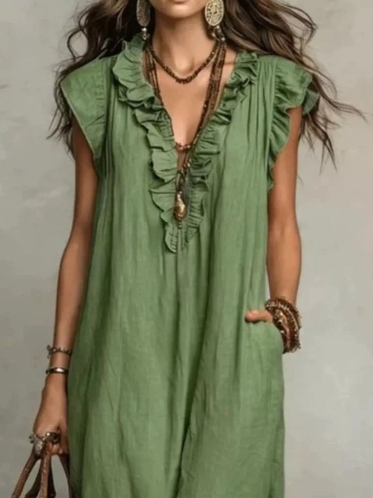 Woman wearing a green dress with ruffled details against a neutral background