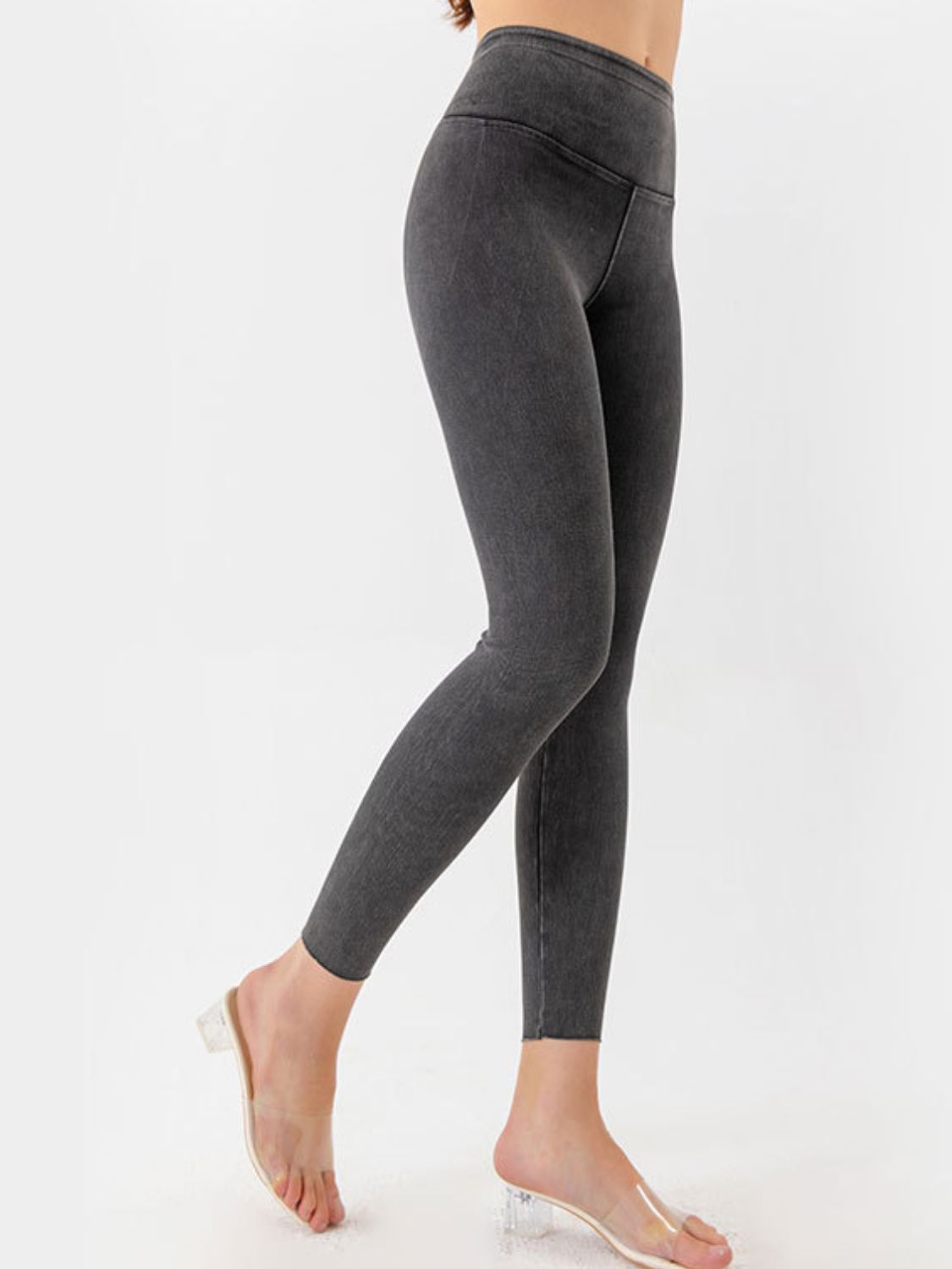 Gray leggings worn by a person on a white background