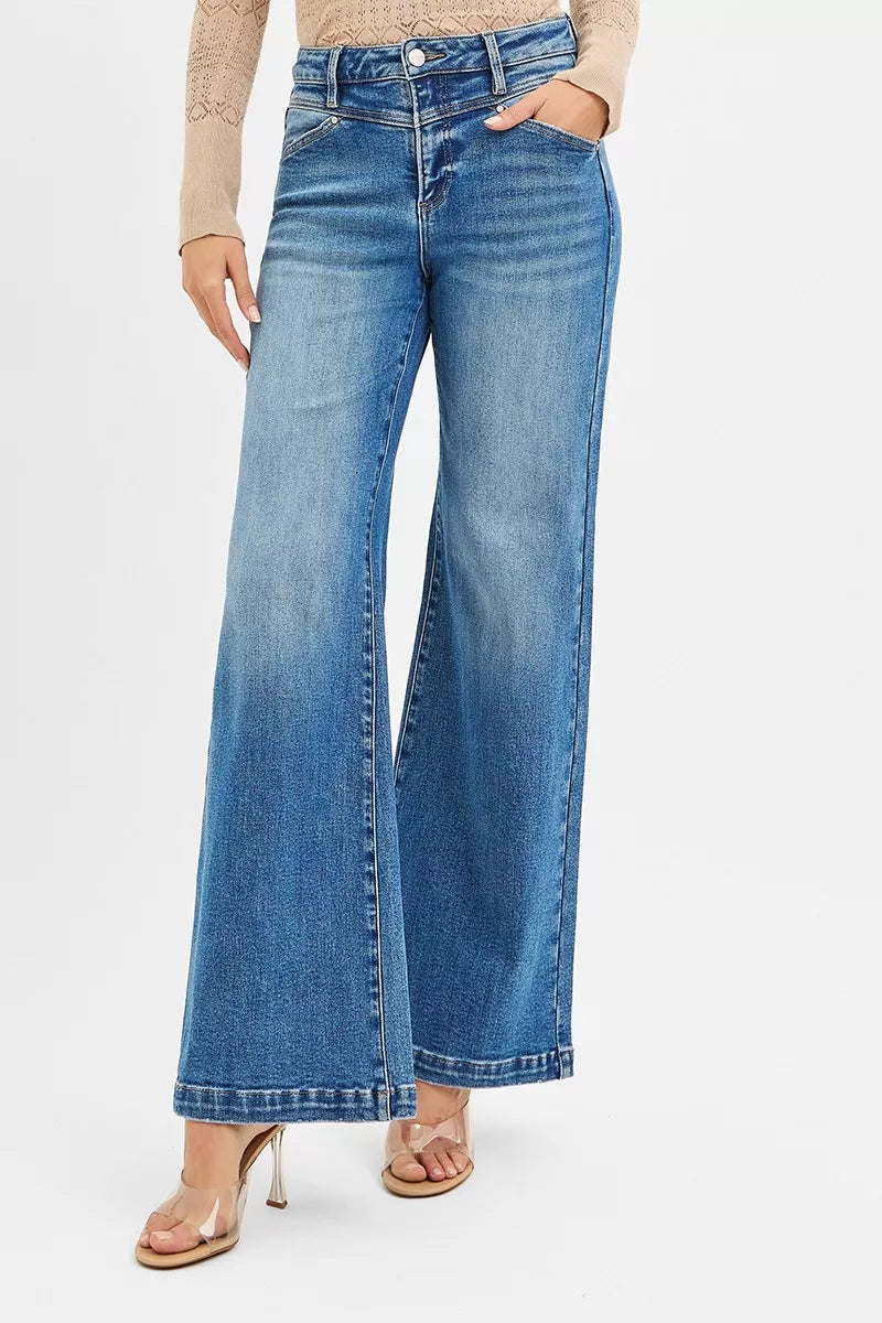 Person wearing blue flared jeans on a white background