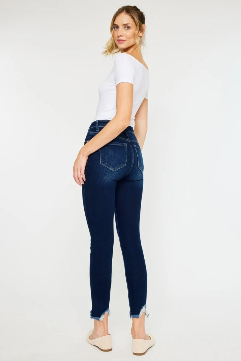 Woman wearing dark blue jeans and a white top on a white background