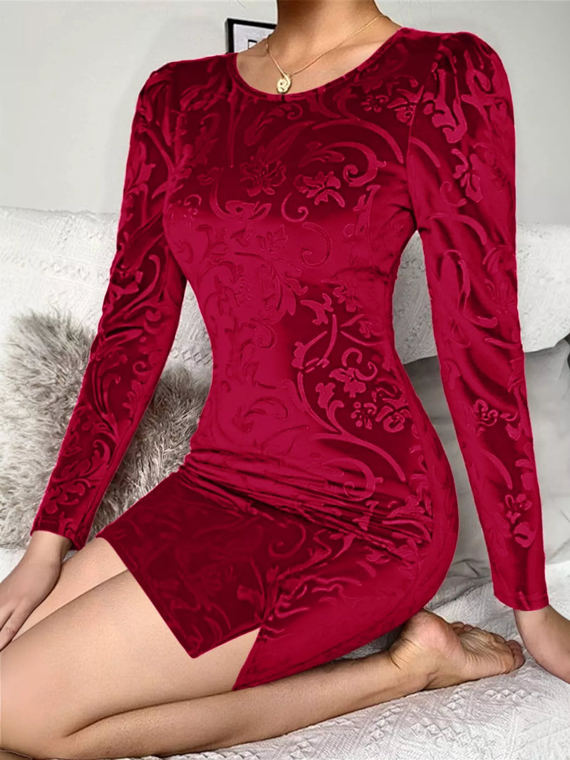 Red patterned dress worn by a person sitting on a white surface.