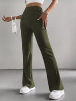 Person wearing green ribbed pants and white sneakers on a gray background