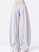 Light gray wide-leg sweatpants with an elastic waistband and drawstrings, shown on a model against a plain white studio background.