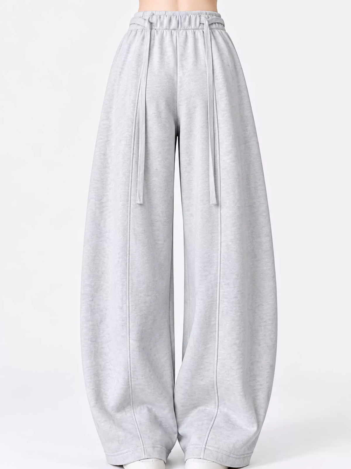 Light gray wide-leg sweatpants with an elastic waistband and drawstrings, shown on a model against a plain white studio background.