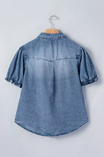 Blue denim shirt with puff sleeves on a hanger against a light gray background