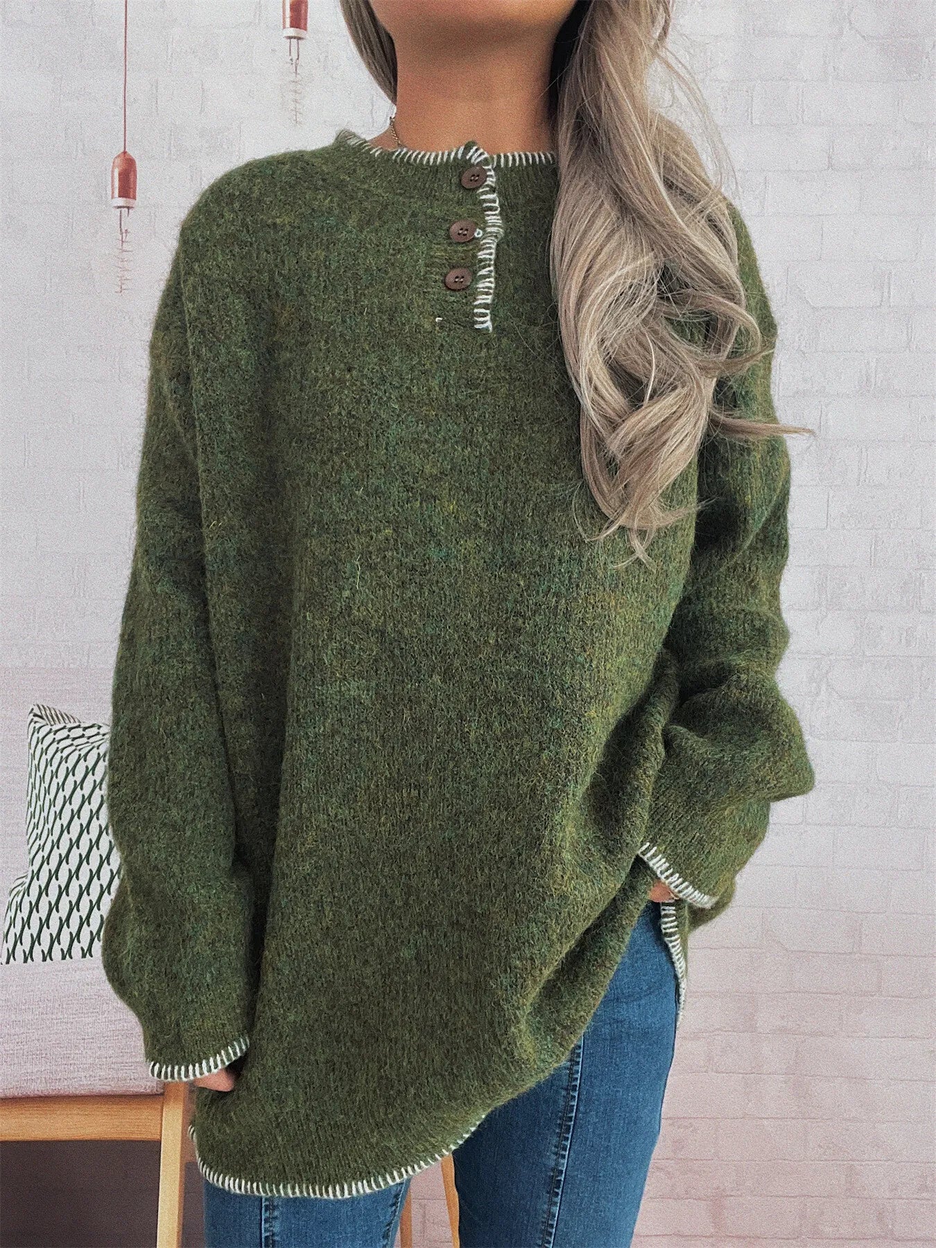 Green sweater worn by a person with a white brick wall background