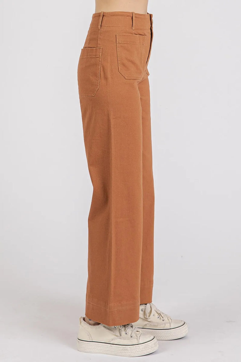 Brown pants worn by a person on a white background