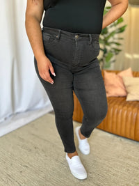 Person wearing black jeans and a black top in a living room setting
