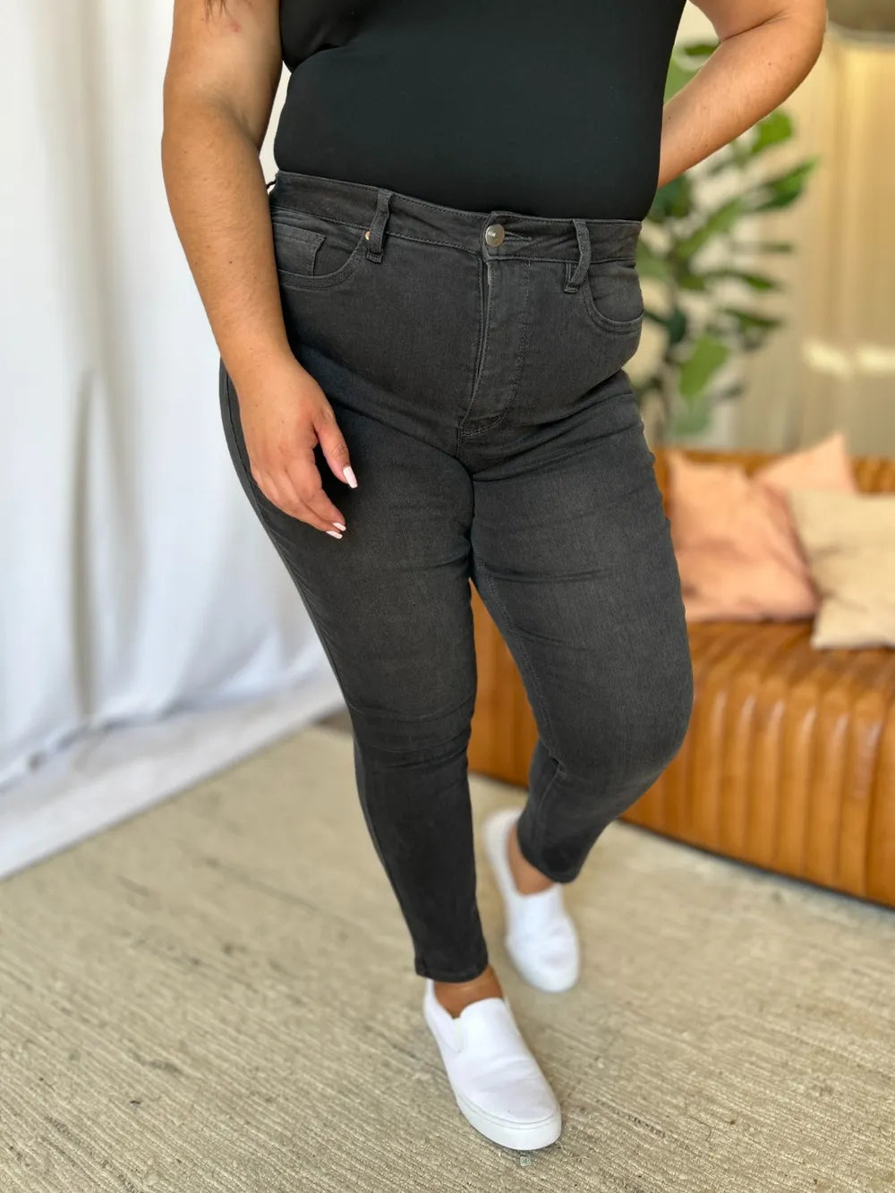 Person wearing black jeans and a black top in a living room setting