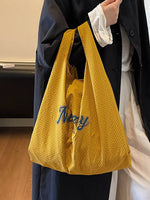 Person holding a yellow textured bag with 'Navy' branding.