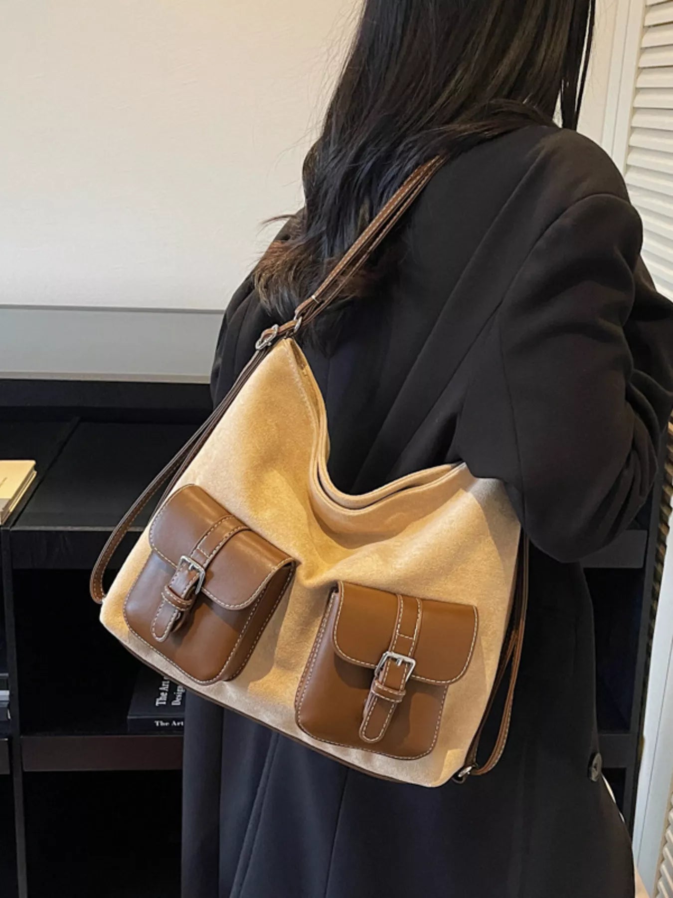 Person wearing a beige handbag with brown accents