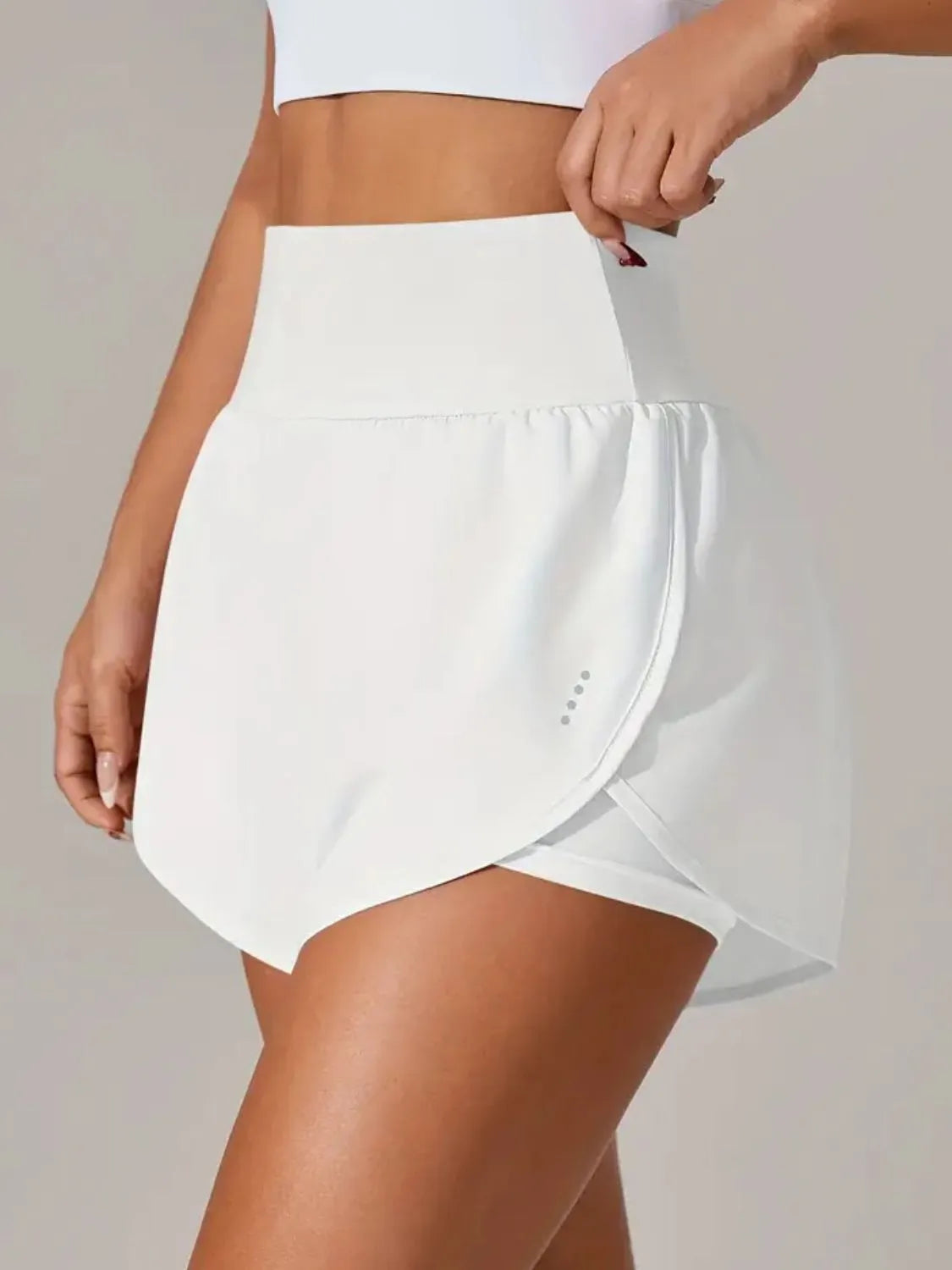 White athletic skirt worn by a person on a plain background
