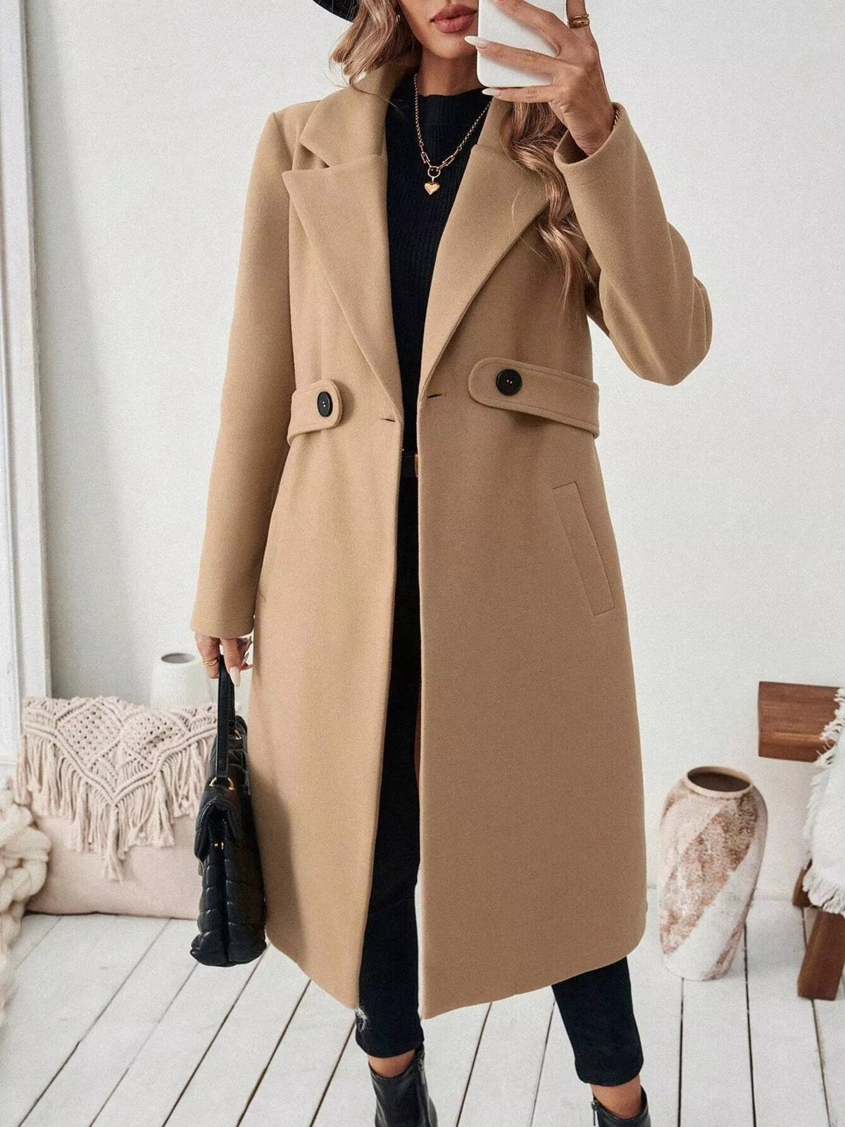 Person wearing a beige coat in a cozy room setting