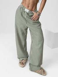 Person wearing green and white striped pants on a white background