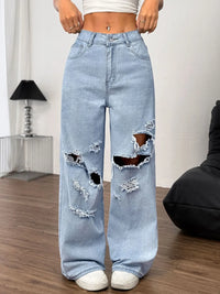 Light blue ripped jeans worn by a person indoors.