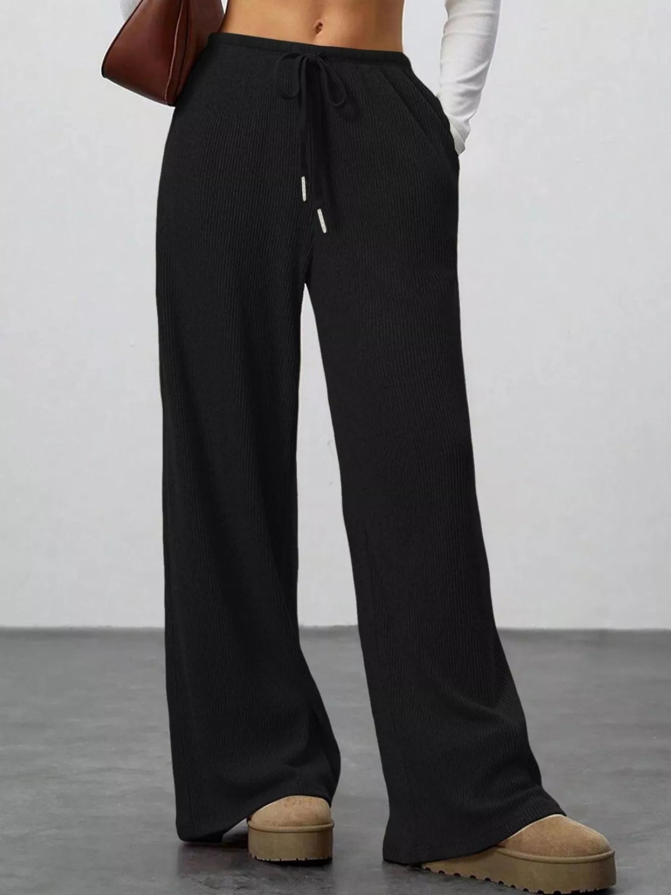 Black wide-leg pants worn by a person on a plain background