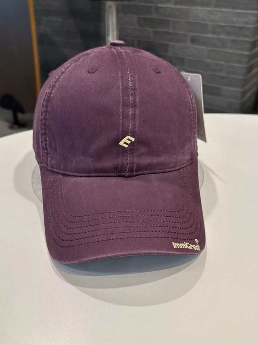 Purple cap with a logo on a white surface