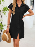 Woman wearing a black dress holding a straw hat indoors.