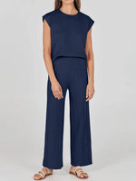 Woman wearing a navy blue jumpsuit on a white background