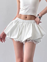 White skirt with lace trim worn by a person on a gray background