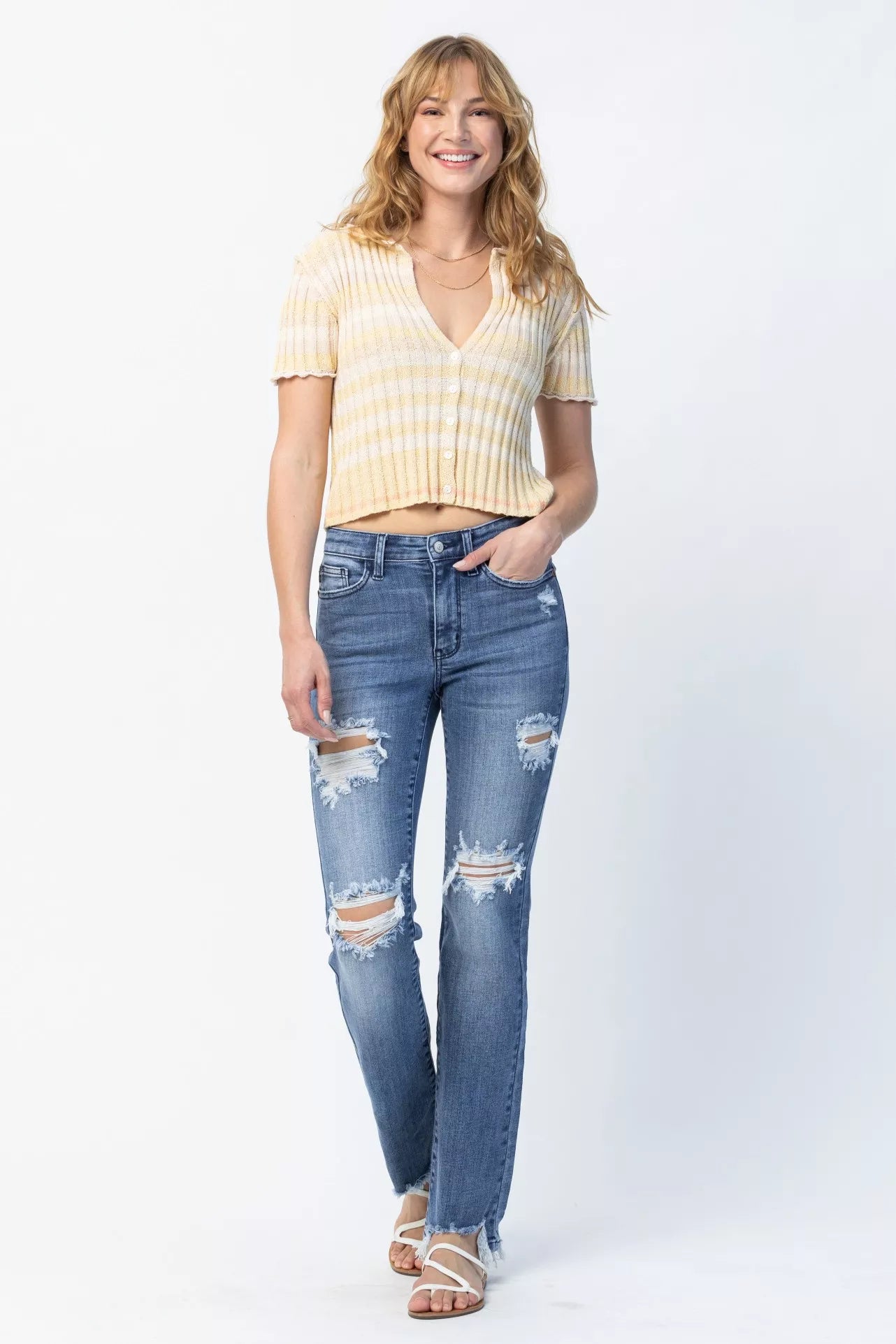 Woman wearing a yellow striped shirt and blue jeans on a white background