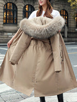 Woman holding biege Women's Detachable Longline Hooded Parka with Faux Fur Trim and Drawstring Waist in her hand