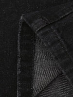 Close-up of black textured fabric with a diagonal pattern on a black background