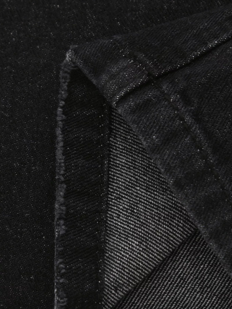 Close-up of black textured fabric with a diagonal pattern on a black background