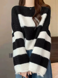 Person wearing a black and white striped sweater with a blurred background