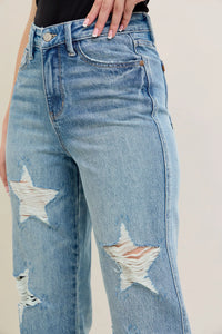 Distressed blue jeans with star designs on a neutral background
