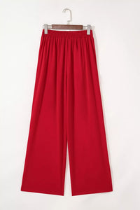 Red pants on a hanger against a white background