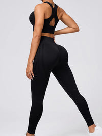 Person wearing a black athletic outfit on a light gray background