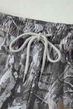 Close-up of a pair of shorts with a floral pattern and drawstring on a light background