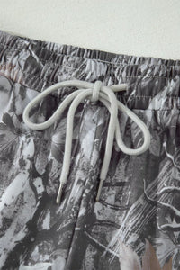 Close-up of a pair of shorts with a floral pattern and drawstring on a light background