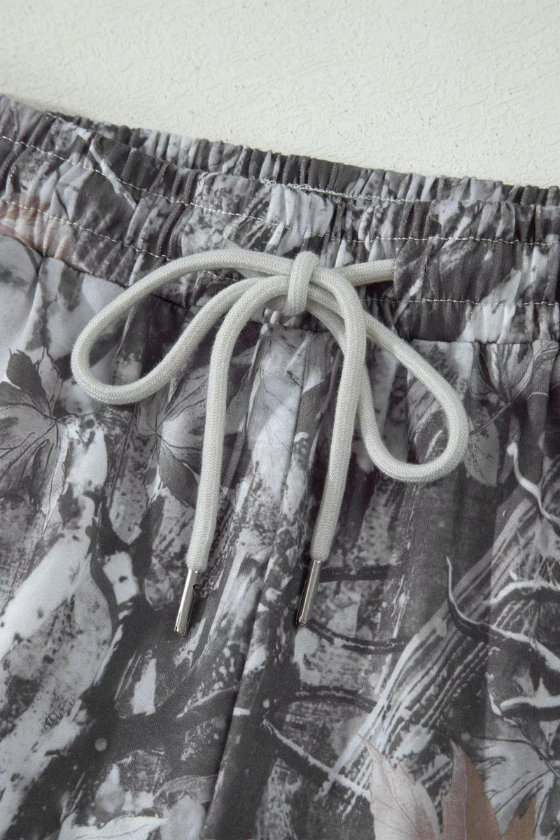 Close-up of a pair of shorts with a floral pattern and drawstring on a light background