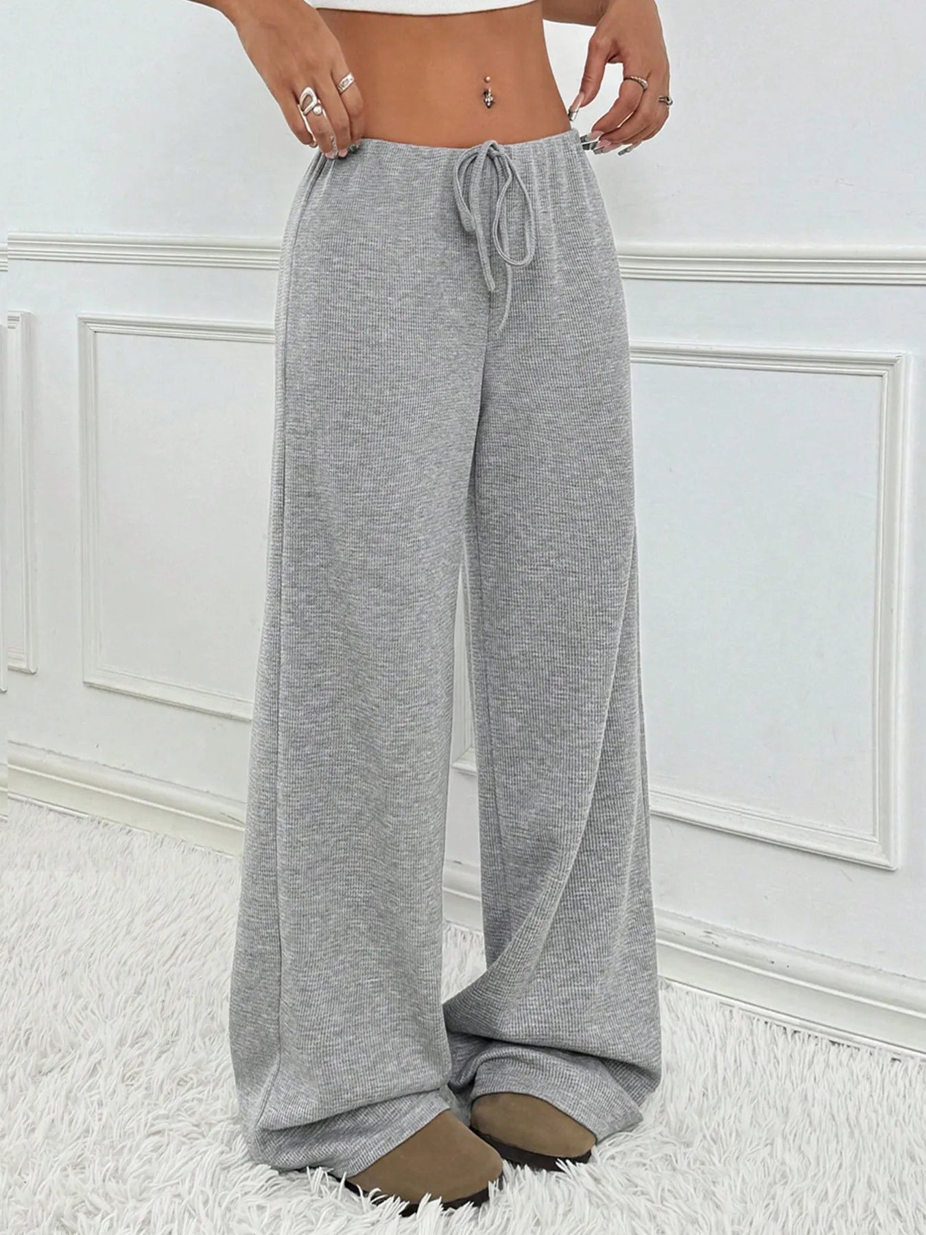 Gray drawstring pants worn by a person on a white background