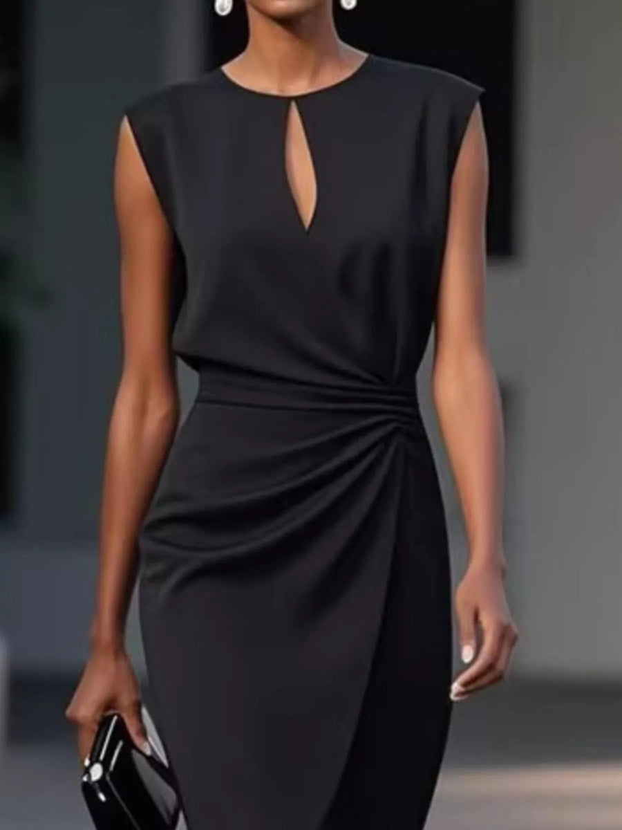 Black dress with a keyhole detail worn by a model against a neutral background