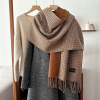 Plaid scarf draped over a coat with a neutral background