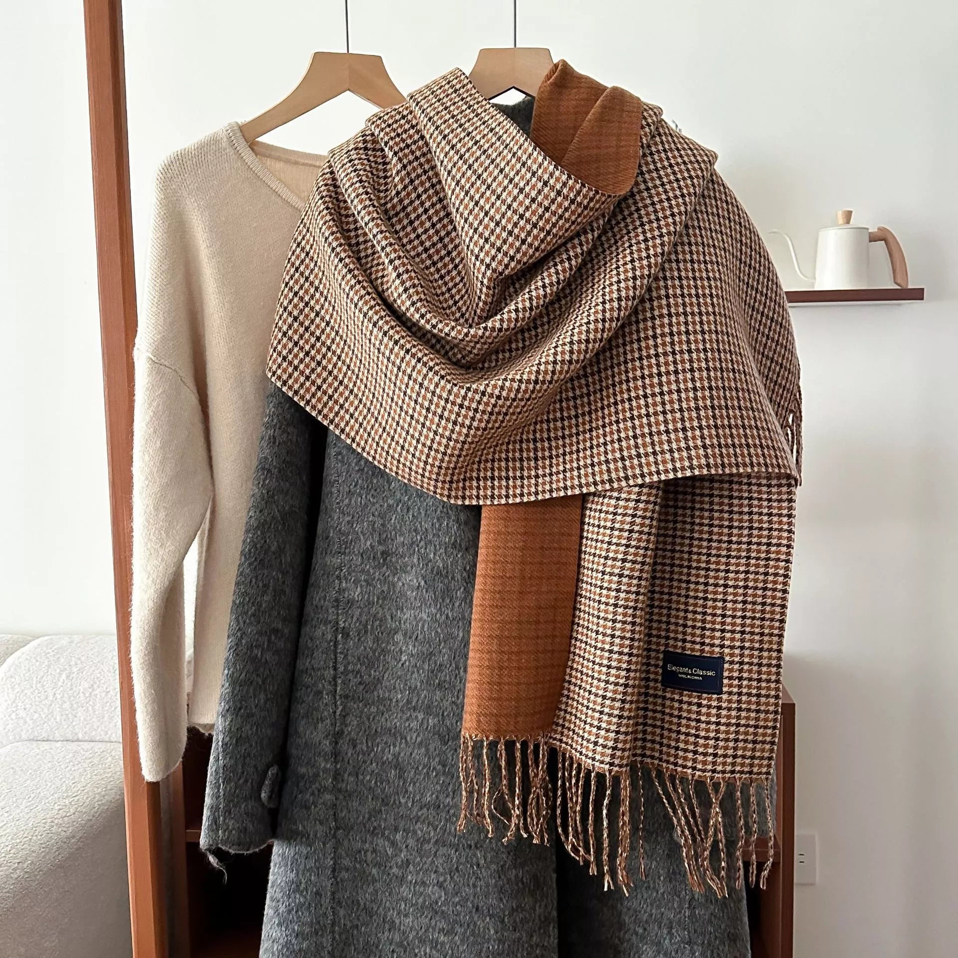 Plaid scarf draped over a coat with a neutral background