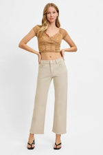 Woman wearing a beige top and light-colored pants on a white background