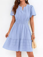 Woman wearing a light blue dress against a white background
