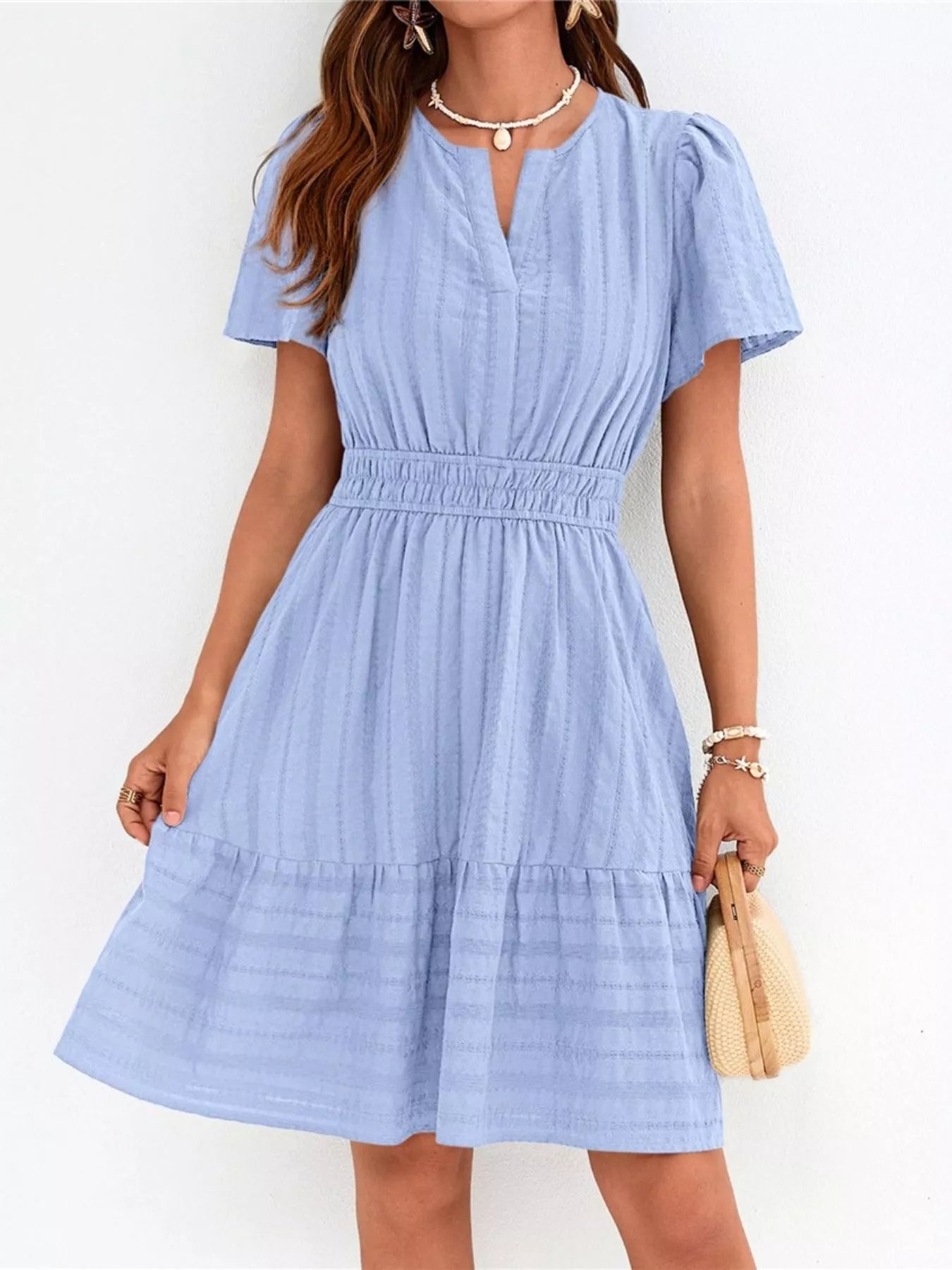 Woman wearing a light blue dress against a white background