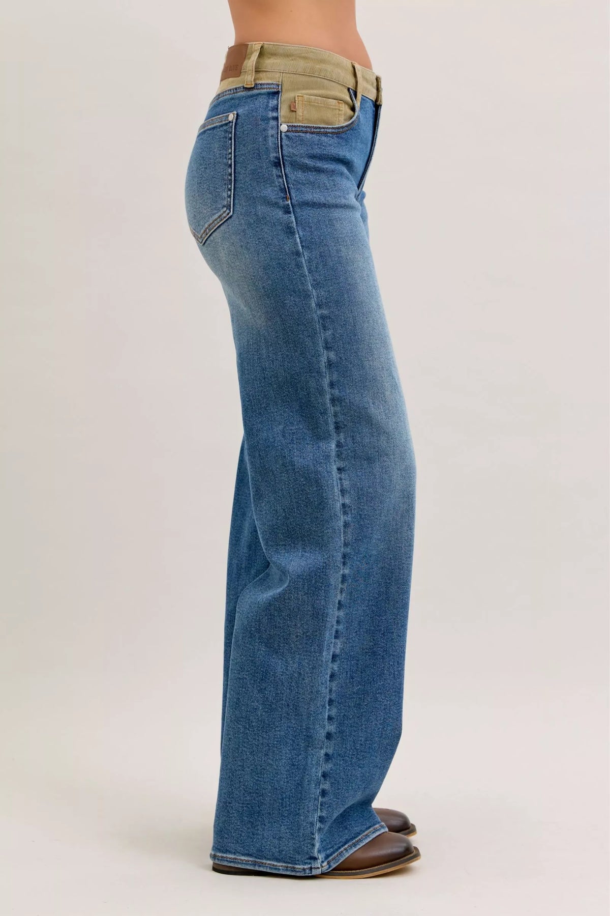 Blue jeans with a beige waistband on a white background