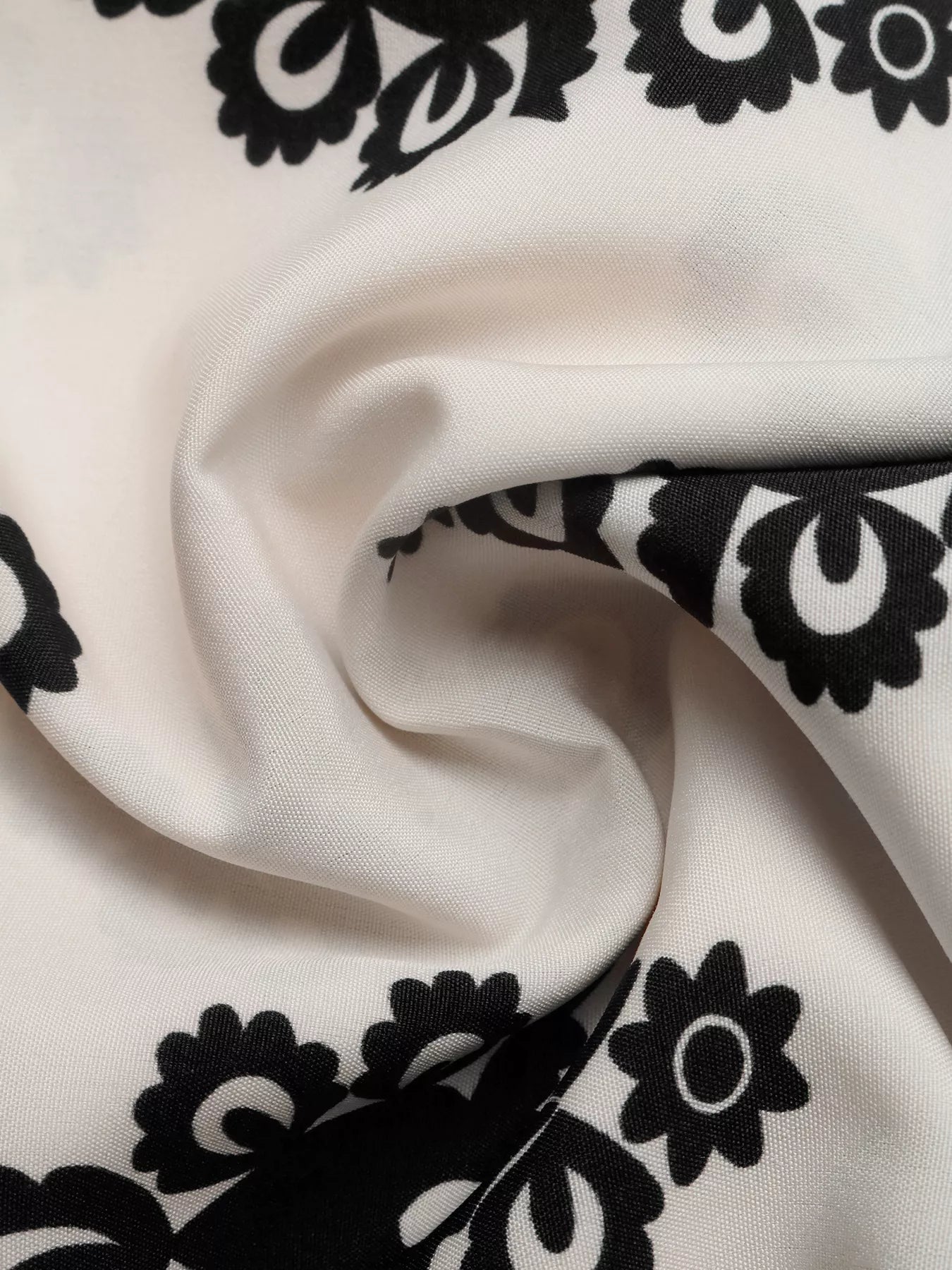 Close-up of white fabric with black floral patterns