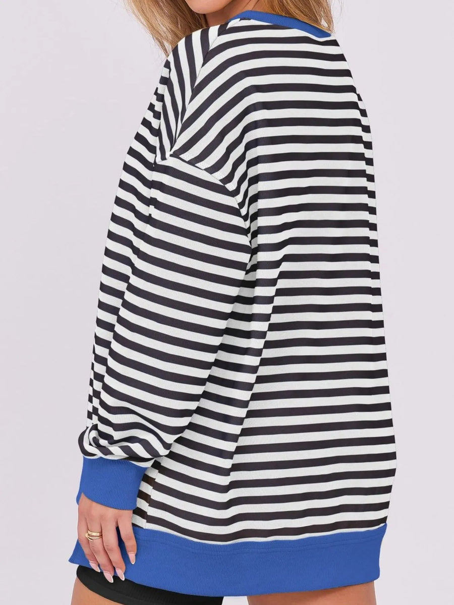 Black and white striped dress with blue trim on a plain background