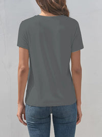 Person wearing a plain gray t-shirt and blue jeans against a light gray background