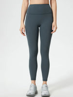Person wearing dark gray leggings on a white background